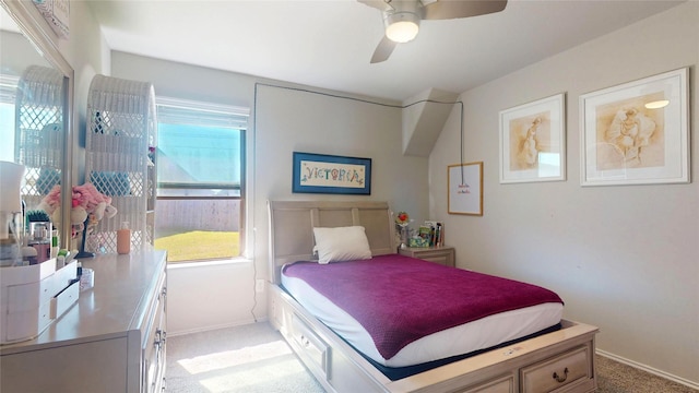 bedroom with baseboards, ceiling fan, multiple windows, and light colored carpet