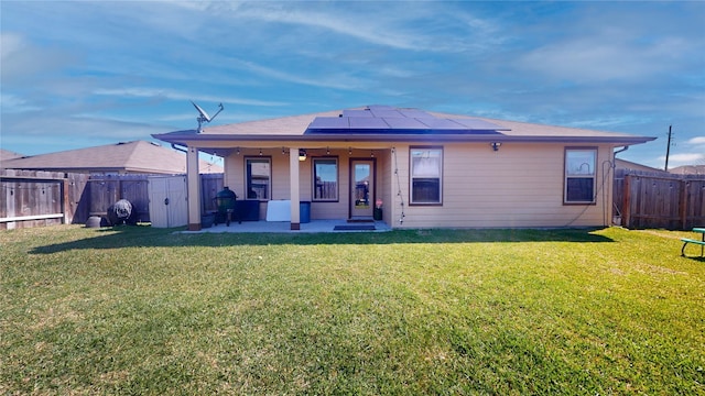 view of front of home with a front yard, roof mounted solar panels, a patio area, a gate, and a fenced backyard