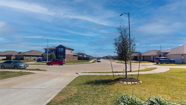 view of street featuring street lighting, sidewalks, and a residential view