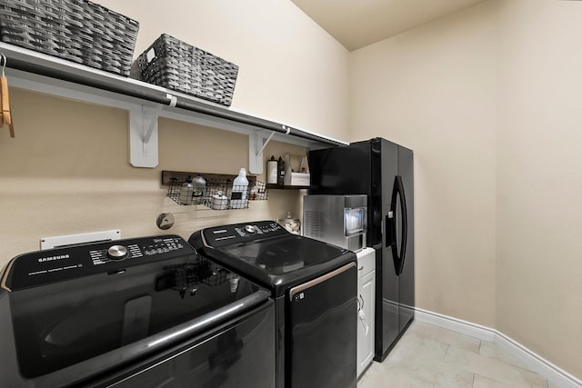 washroom with laundry area, baseboards, and washing machine and clothes dryer