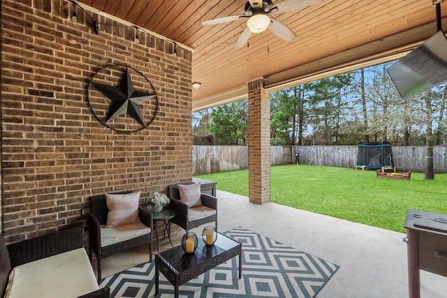 view of patio with a fenced backyard, a trampoline, an outdoor hangout area, and a ceiling fan