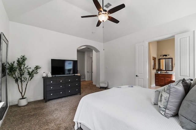 carpeted bedroom with arched walkways, visible vents, vaulted ceiling, ceiling fan, and baseboards