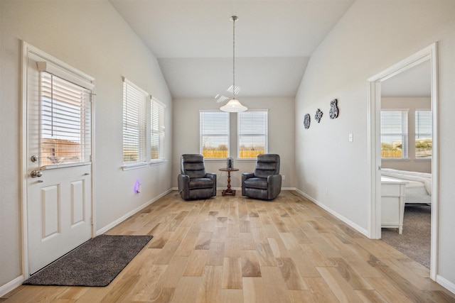 unfurnished room featuring light wood-type flooring, vaulted ceiling, and baseboards