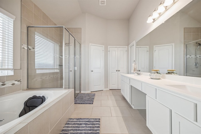 bathroom with double vanity, a garden tub, a shower stall, and tile patterned floors