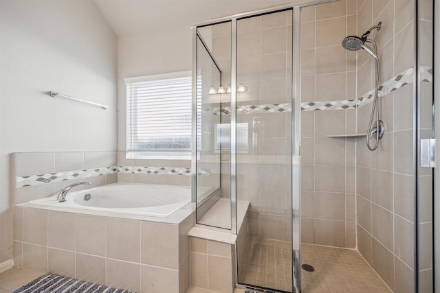 bathroom with a stall shower and a garden tub