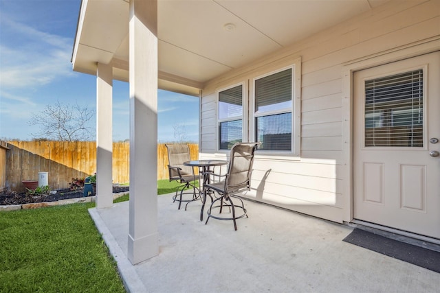 view of patio with outdoor dining area and fence