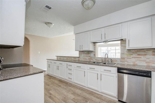 kitchen featuring visible vents, light wood-style flooring, stainless steel dishwasher, white cabinets, and a sink