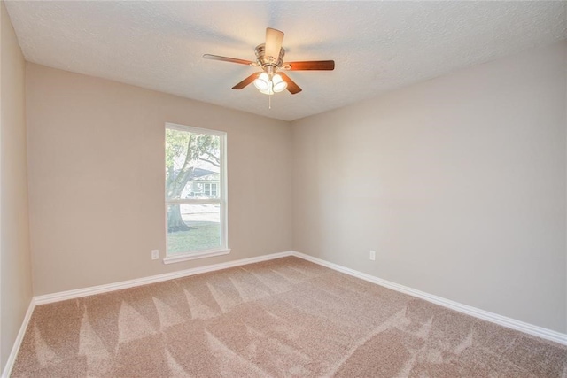 unfurnished room featuring a textured ceiling, carpet floors, and baseboards