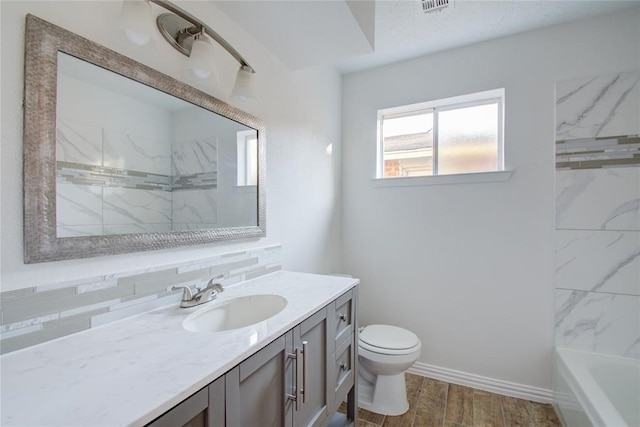 full bathroom with toilet, wood finished floors, visible vents, vanity, and baseboards