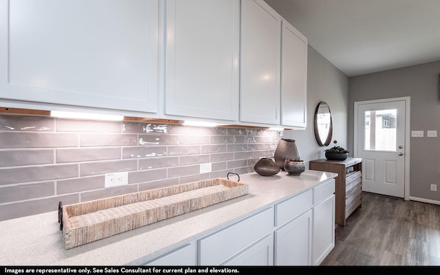 kitchen with light stone countertops, white cabinetry, backsplash, and wood finished floors