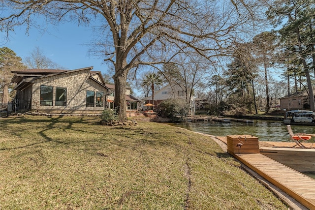 view of yard featuring a boat dock and a water view