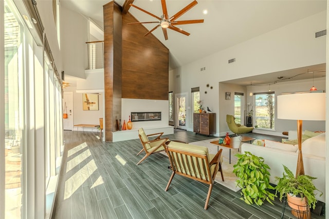 living room with high vaulted ceiling, wood finish floors, a large fireplace, and visible vents