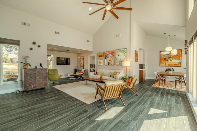 living area with high vaulted ceiling, visible vents, and wood finish floors