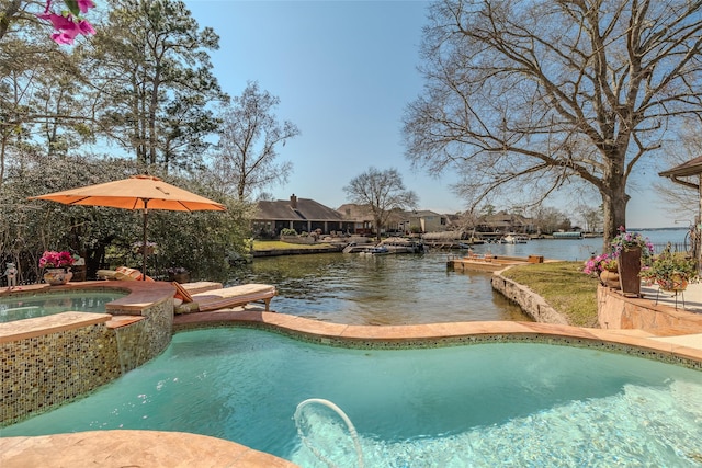 view of swimming pool featuring a pool with connected hot tub and a water view