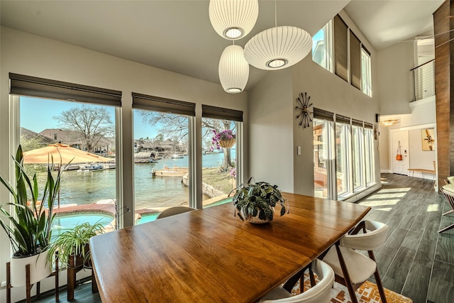 dining space featuring a water view and wood finished floors