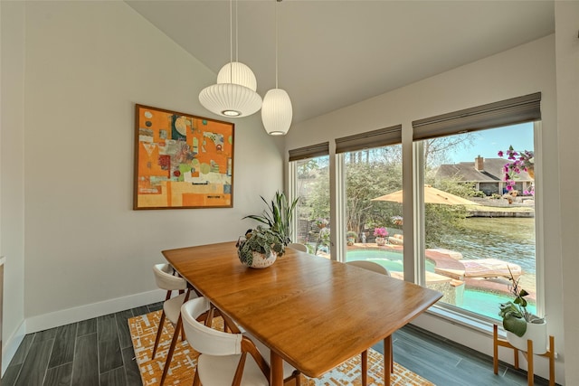 dining area with lofted ceiling, dark wood-style flooring, and baseboards