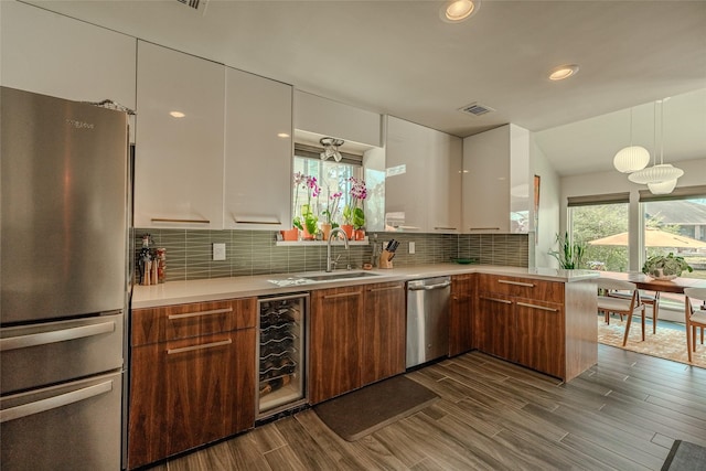 kitchen with visible vents, modern cabinets, wine cooler, appliances with stainless steel finishes, and a sink