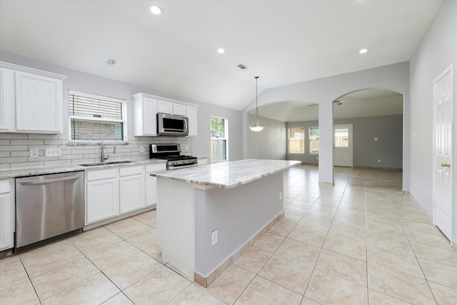 kitchen with appliances with stainless steel finishes, backsplash, light tile patterned flooring, and a sink