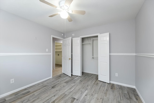 unfurnished bedroom with ceiling fan, a closet, baseboards, and wood finished floors