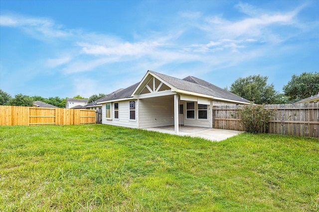 rear view of house with a lawn, a patio area, and a fenced backyard