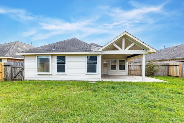 rear view of property featuring a patio, a yard, a shingled roof, and a fenced backyard