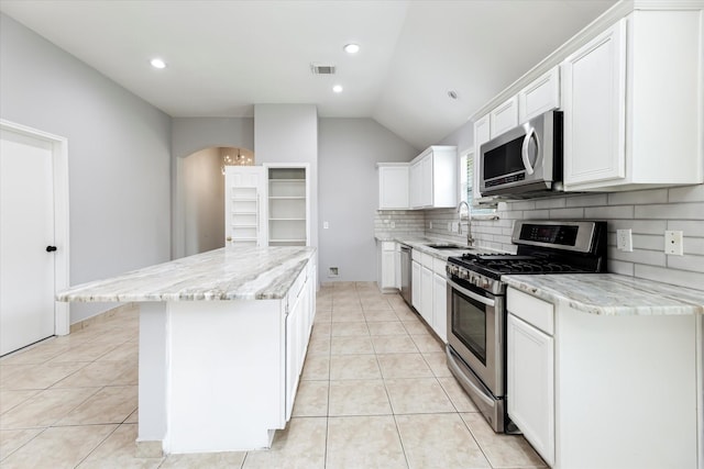 kitchen with light tile patterned floors, stainless steel appliances, a sink, visible vents, and decorative backsplash