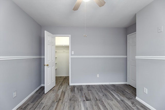 spare room with ceiling fan, baseboards, and wood finished floors