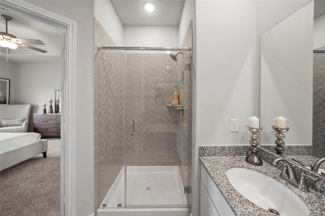 full bath with ensuite bathroom, a shower stall, vanity, and a ceiling fan