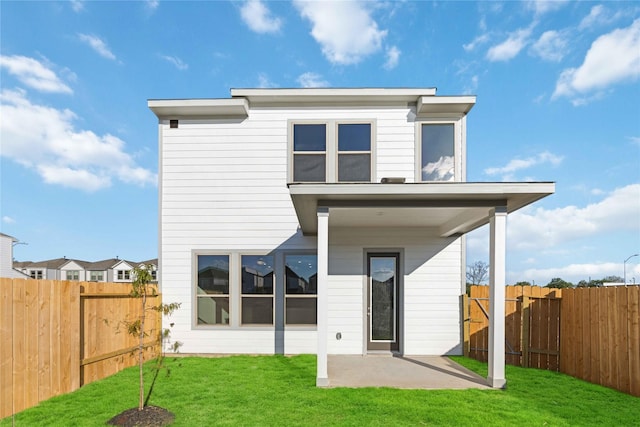 back of property featuring a yard, a patio area, and a fenced backyard