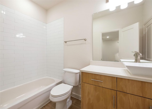 bathroom with baseboards, bathing tub / shower combination, toilet, wood finished floors, and vanity