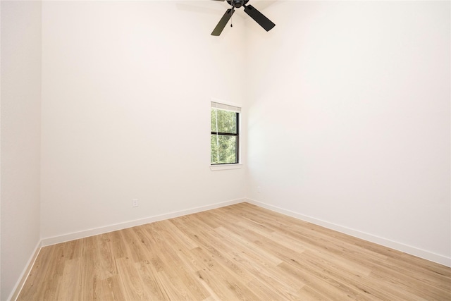 spare room with light wood finished floors, ceiling fan, and baseboards