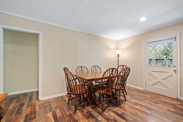 dining area featuring ornamental molding, dark wood-type flooring, and baseboards