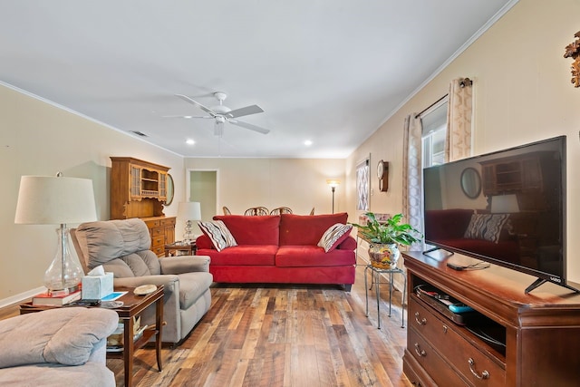 living area featuring recessed lighting, visible vents, light wood-style floors, ornamental molding, and a ceiling fan