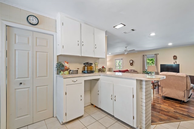 kitchen with visible vents, open floor plan, a peninsula, light countertops, and white cabinetry