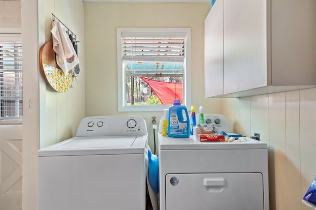 laundry room featuring washer and dryer, cabinet space, and plenty of natural light