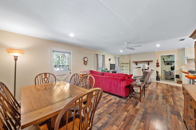 dining area featuring recessed lighting, visible vents, a ceiling fan, a brick fireplace, and dark wood-style floors