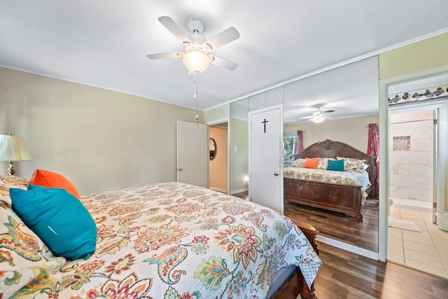 bedroom with ceiling fan, wood finished floors, and ensuite bathroom