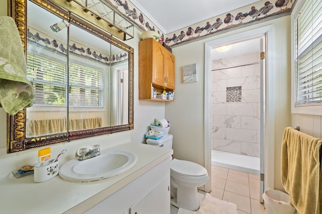 bathroom with vanity, a tile shower, toilet, and tile patterned floors