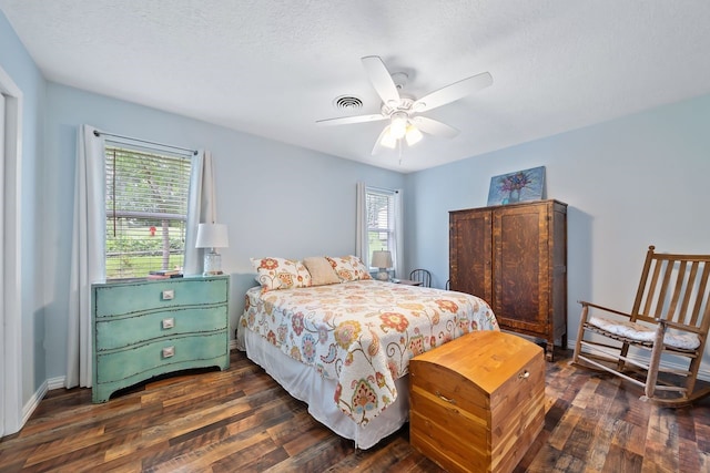 bedroom featuring dark wood-style floors, multiple windows, visible vents, and baseboards