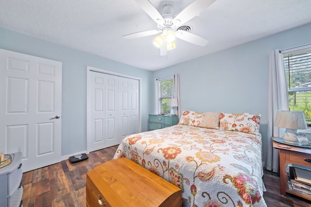 bedroom with dark wood-style floors, a closet, a textured ceiling, and a ceiling fan