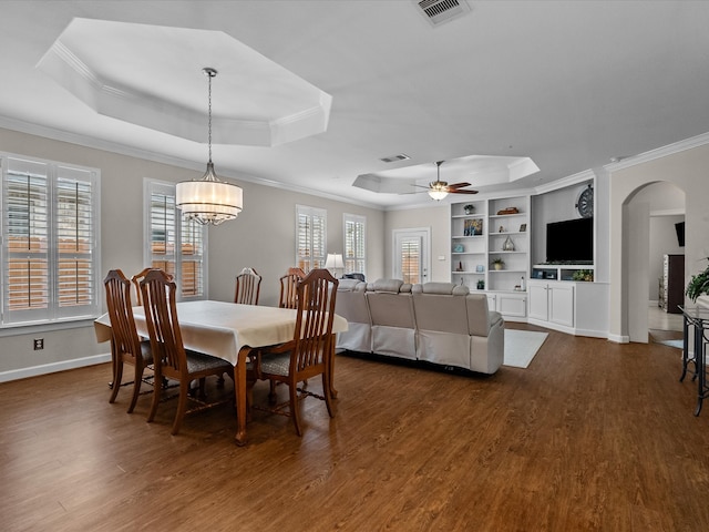 dining room with dark wood finished floors, visible vents, and a raised ceiling