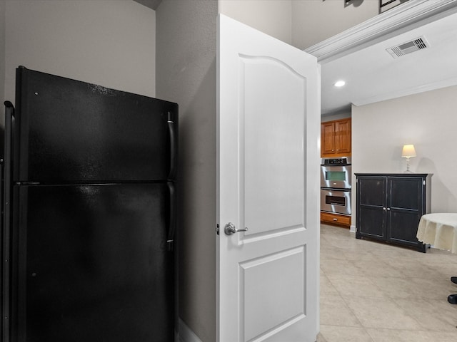 kitchen with visible vents, double oven, recessed lighting, brown cabinets, and freestanding refrigerator