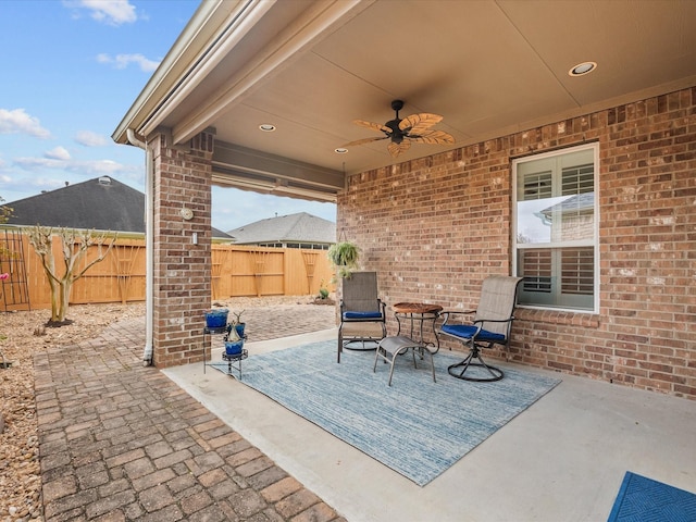 view of patio featuring ceiling fan and fence