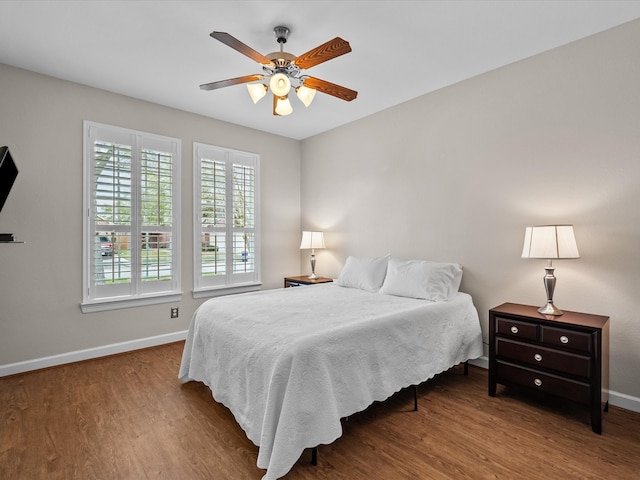 bedroom with wood finished floors, baseboards, and ceiling fan