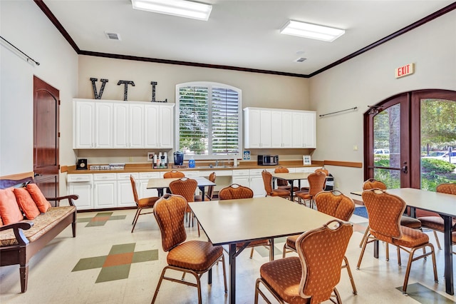 dining area with visible vents, light floors, crown molding, and french doors