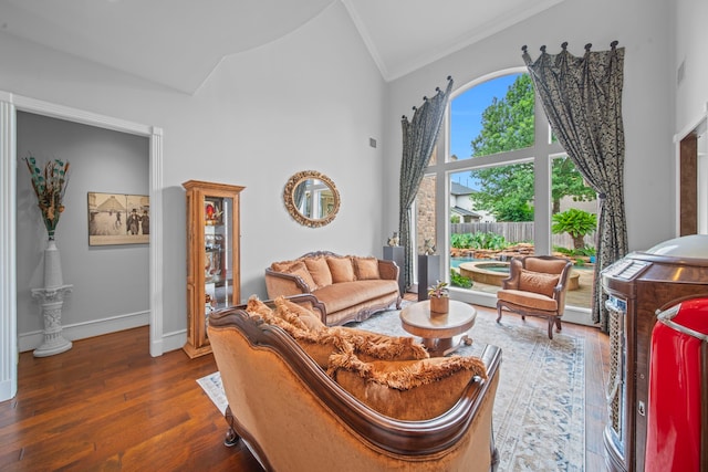 living room featuring baseboards, high vaulted ceiling, wood finished floors, and crown molding