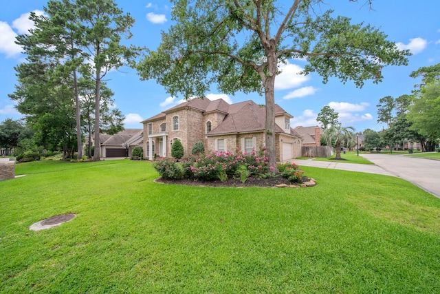 view of front of house with brick siding, a front lawn, and driveway