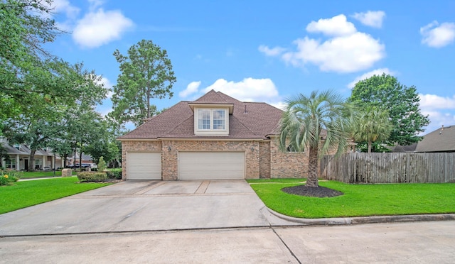 view of front of home with brick siding, a front lawn, fence, concrete driveway, and a garage