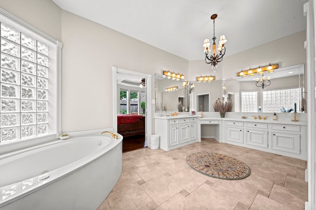 bathroom with plenty of natural light, a garden tub, vanity, and ceiling fan with notable chandelier