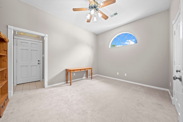 carpeted spare room featuring visible vents, baseboards, and ceiling fan